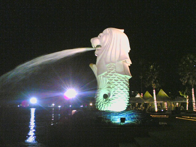 an illuminated large fountain with a statue