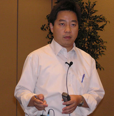an asian man holding two electronic devices in his hands