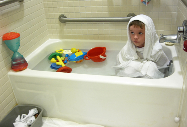 the little boy is in the bathtub