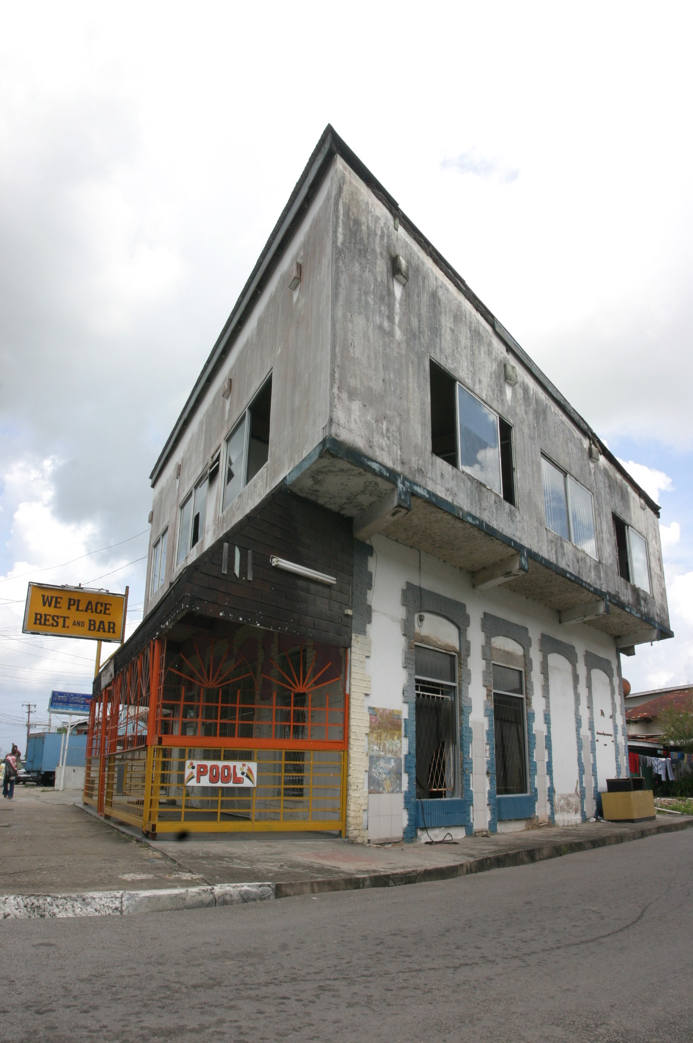an old commercial building being demolished with signs on the front and side