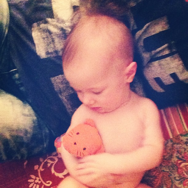 there is a small baby holding an elephant toy