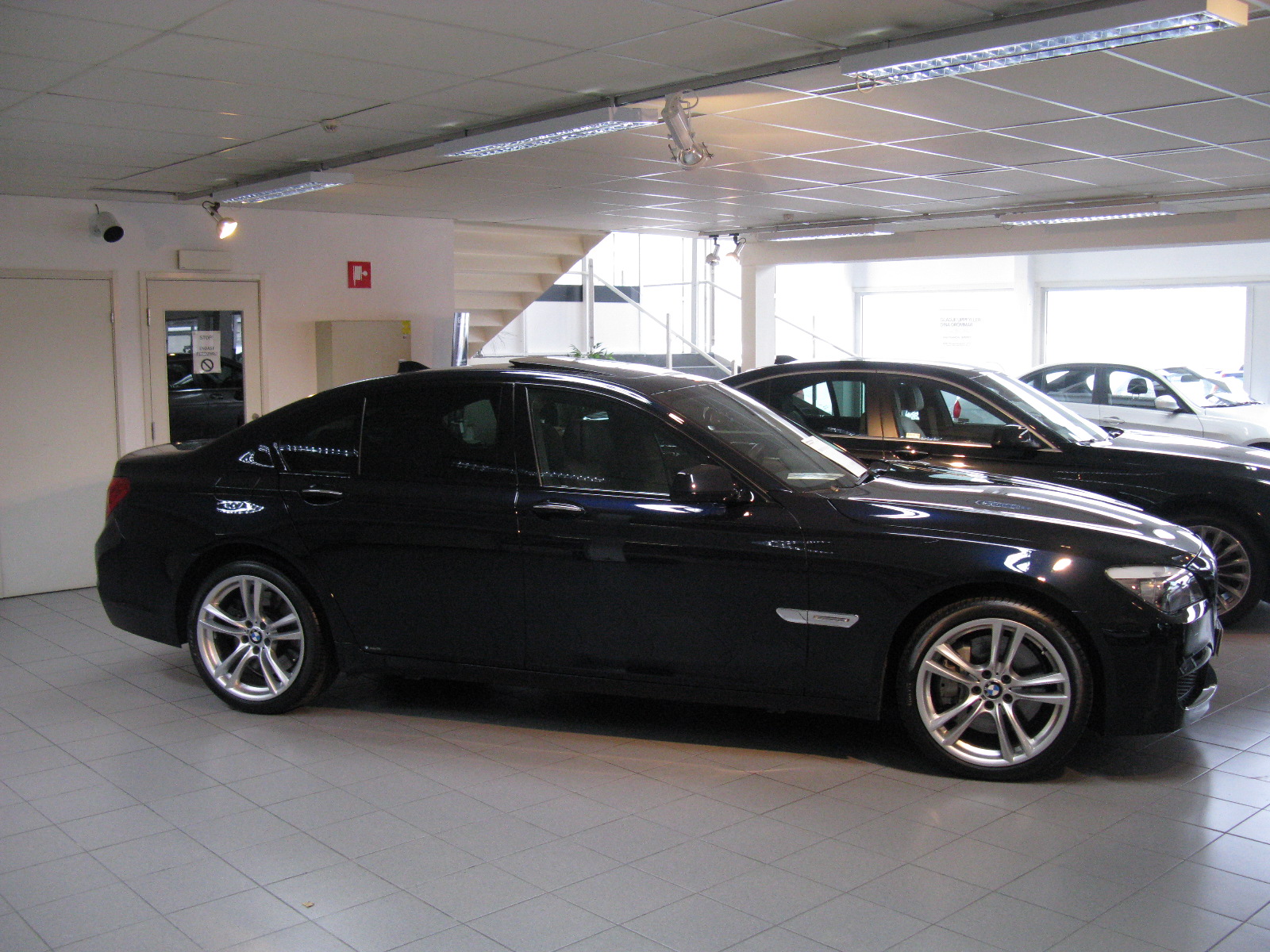 black bmw is sitting in a parking garage