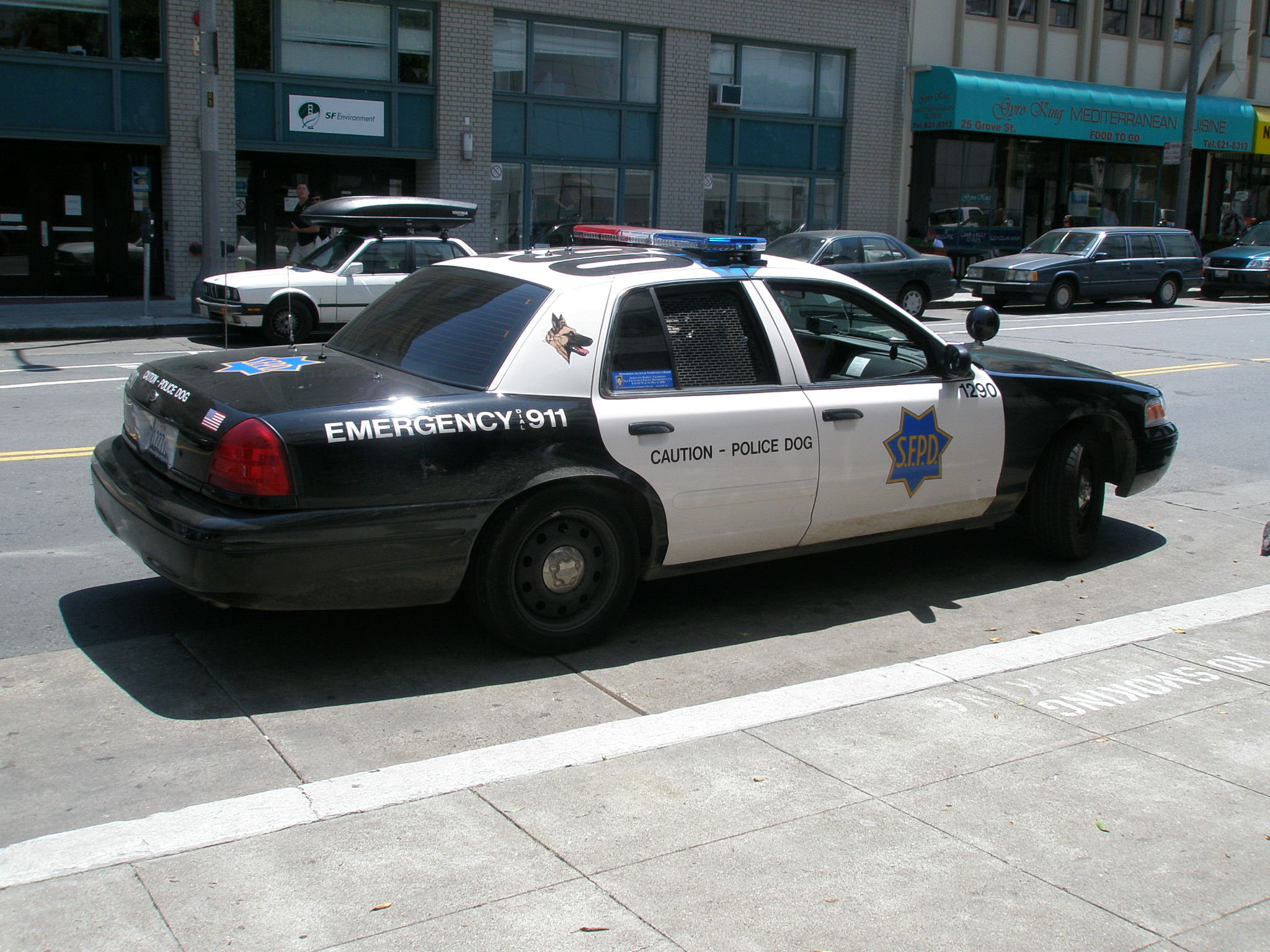 a police car parked on the street in front of a shopping center