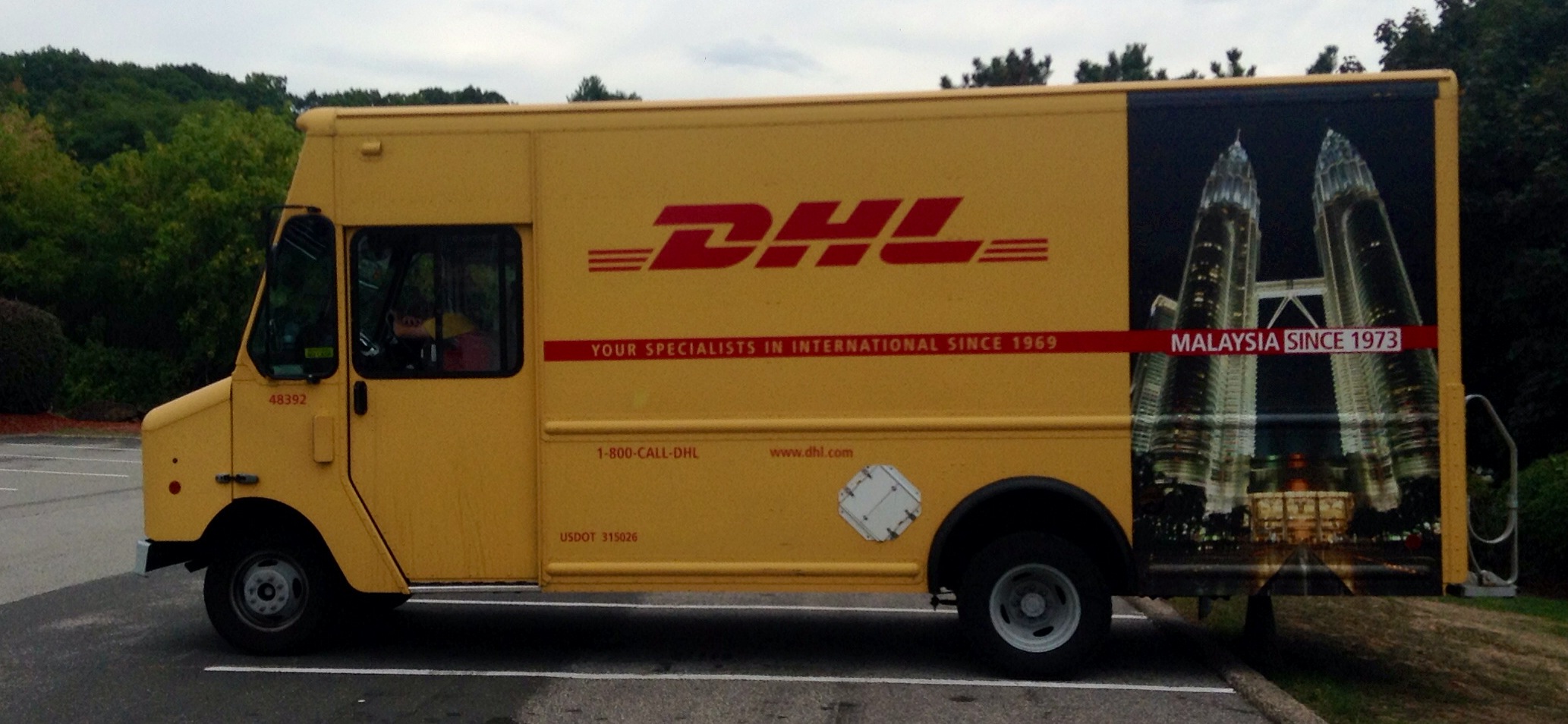 a dhl delivery truck parked on the side of the road