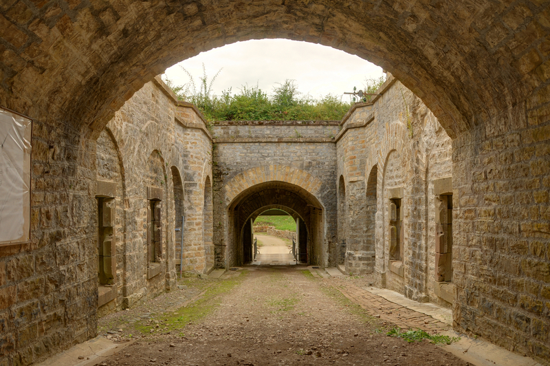 a hallway has a stone tunnel between two buildings