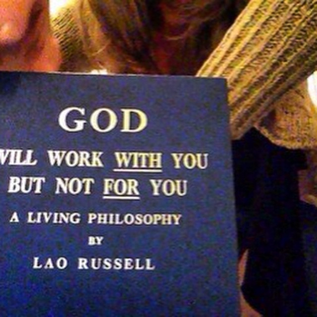 a person holding up a blue book with the words god