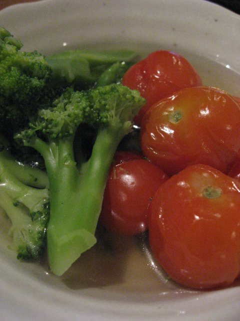 the plate has tomatoes and broccoli in it