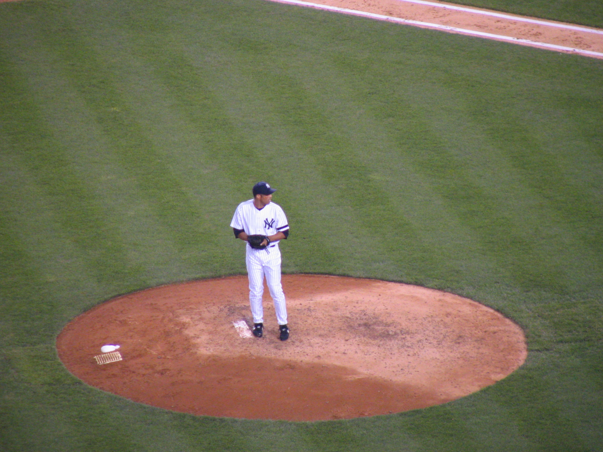 a baseball player stands on the pitcher's mound in his uniform