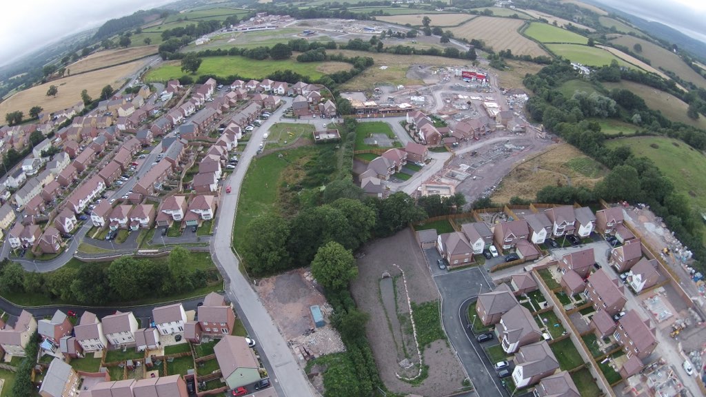 a bird - eye view of a residential area in an area with green fields