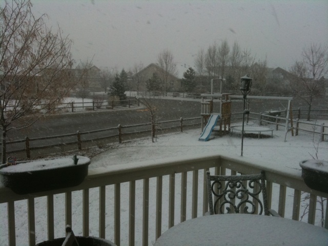 there is a snow covered deck with chairs and tables