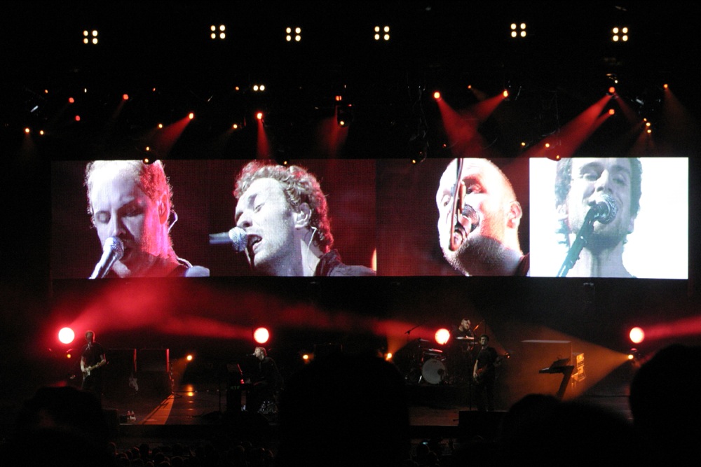 concert video projection with the band in front of them