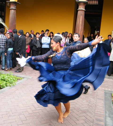 women dancing around on a brick floor in a courtyard