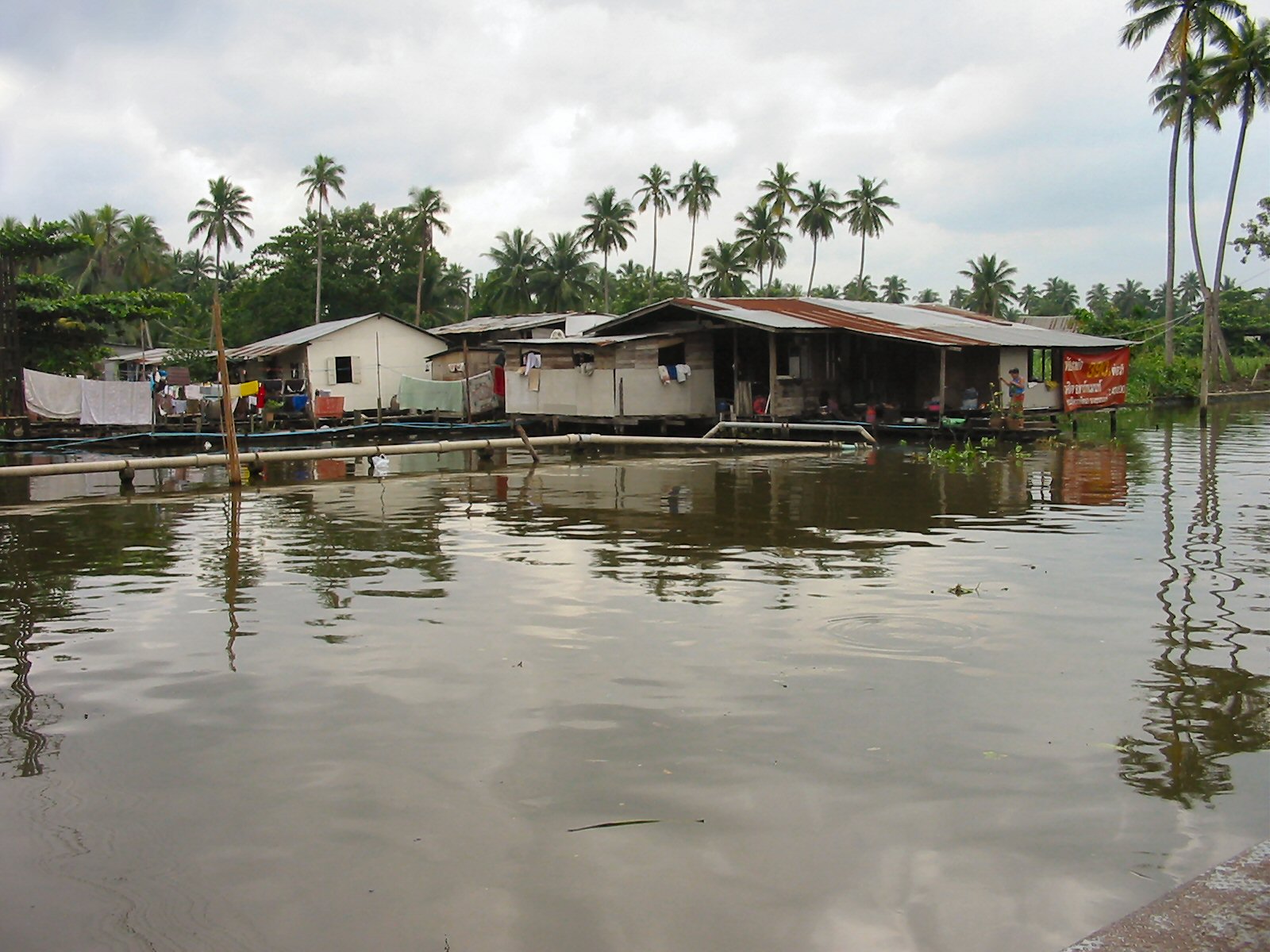 several houses on stilts in front of the water
