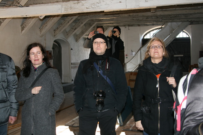 group of people standing around and taking pictures in a building