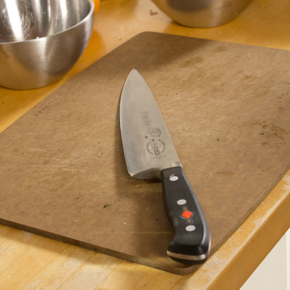 a knife sitting on top of a  board on a counter