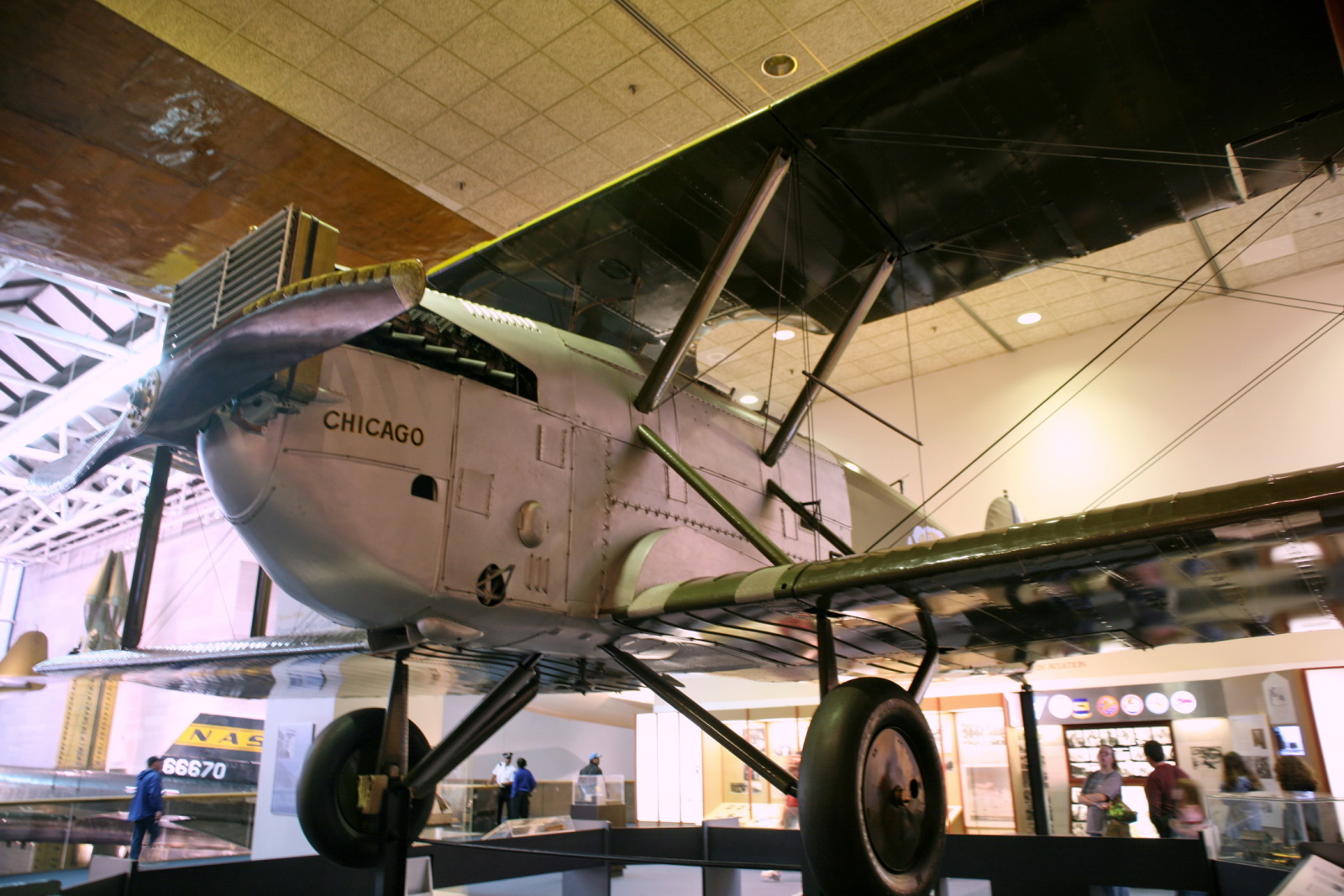 a plane displayed inside a museum with people looking at it