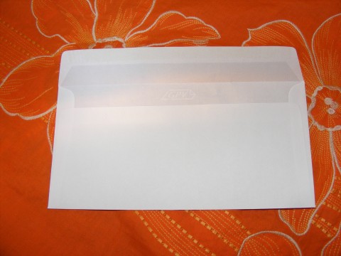 a empty white envelope is on a colorful tablecloth