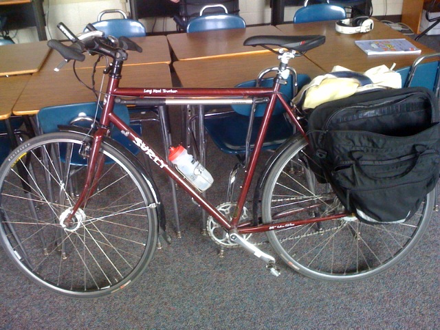 a bicycle with a backpack on it is parked by a conference room table