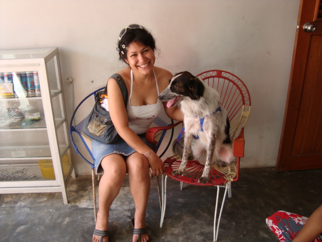 a young woman sits in a chair and pets her dog