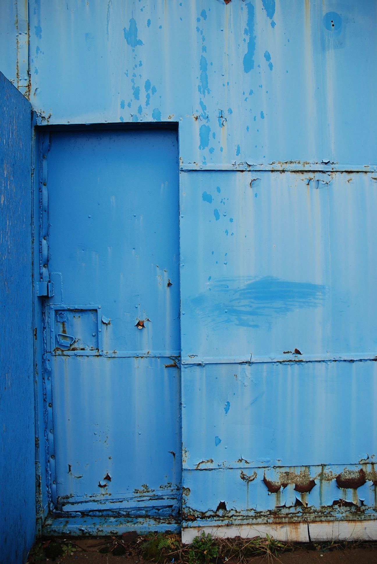 a wall with blue paint that is almost rusted