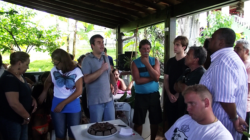 a crowd of people gathered to watch a man about to eat cake