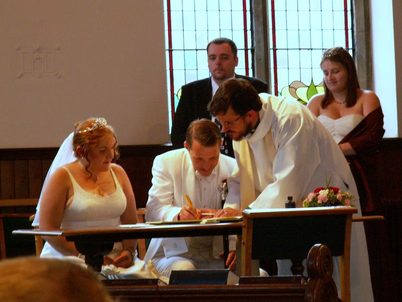 people signing papers and pictures at a wedding ceremony