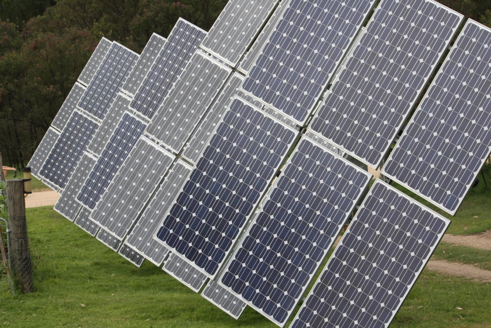 a group of solar panels are on top of a green field