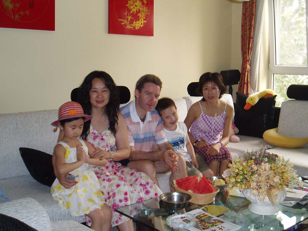 a family of four gathered on a couch in a living room