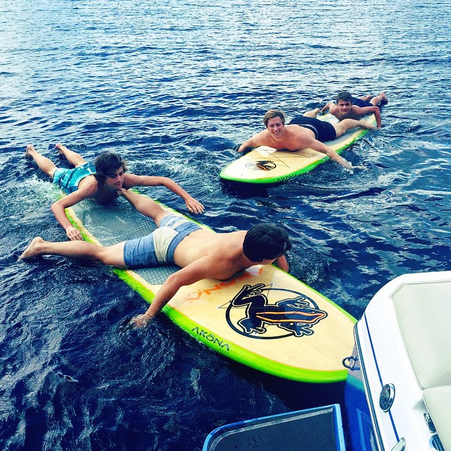 group of men lying on surfboards in the ocean