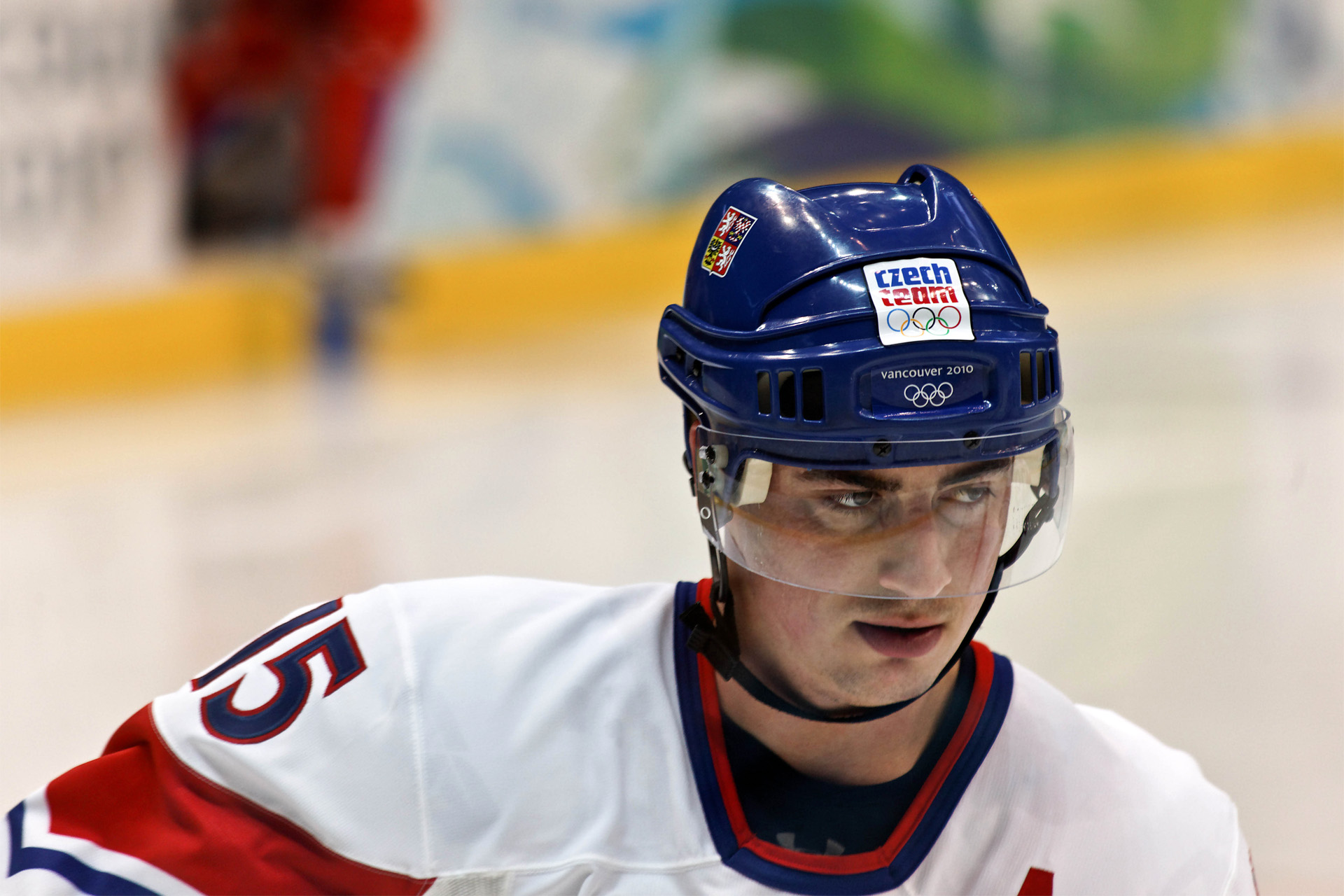 a male hockey player wears a red, white and blue uniform