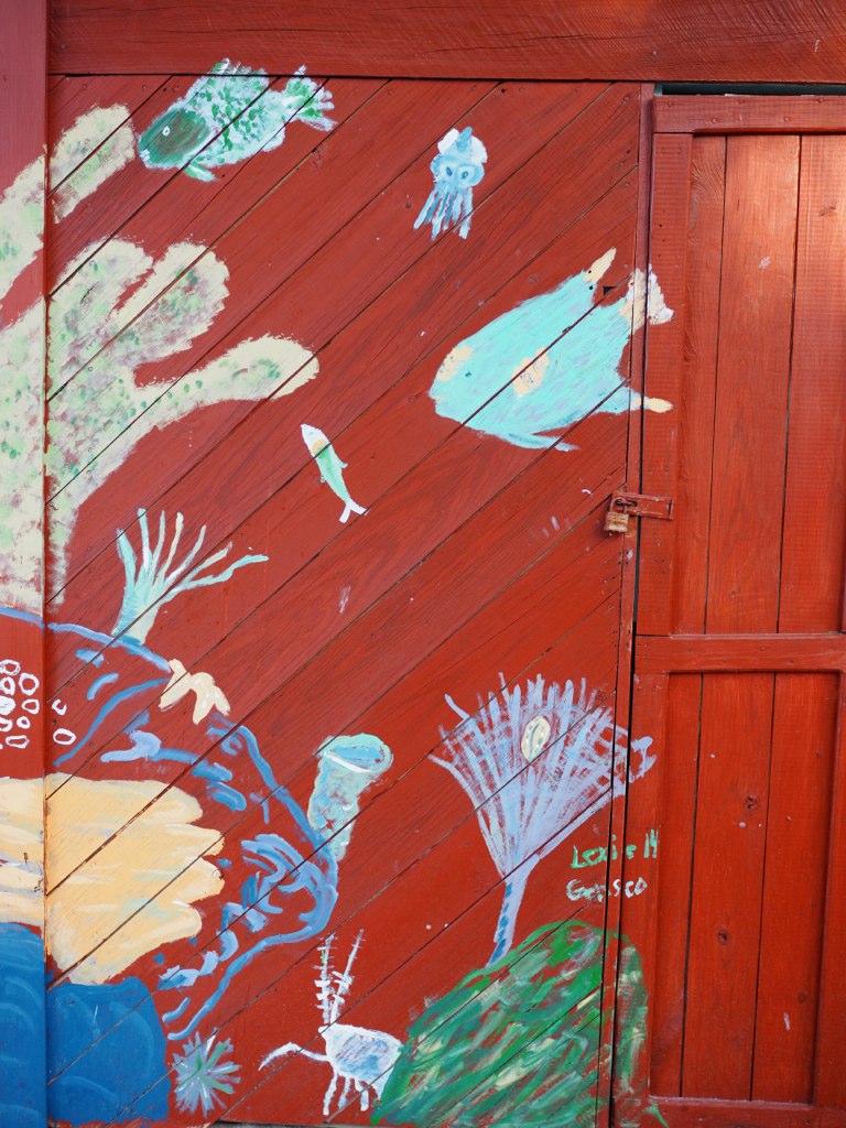 a wooden fence covered in art work with many images