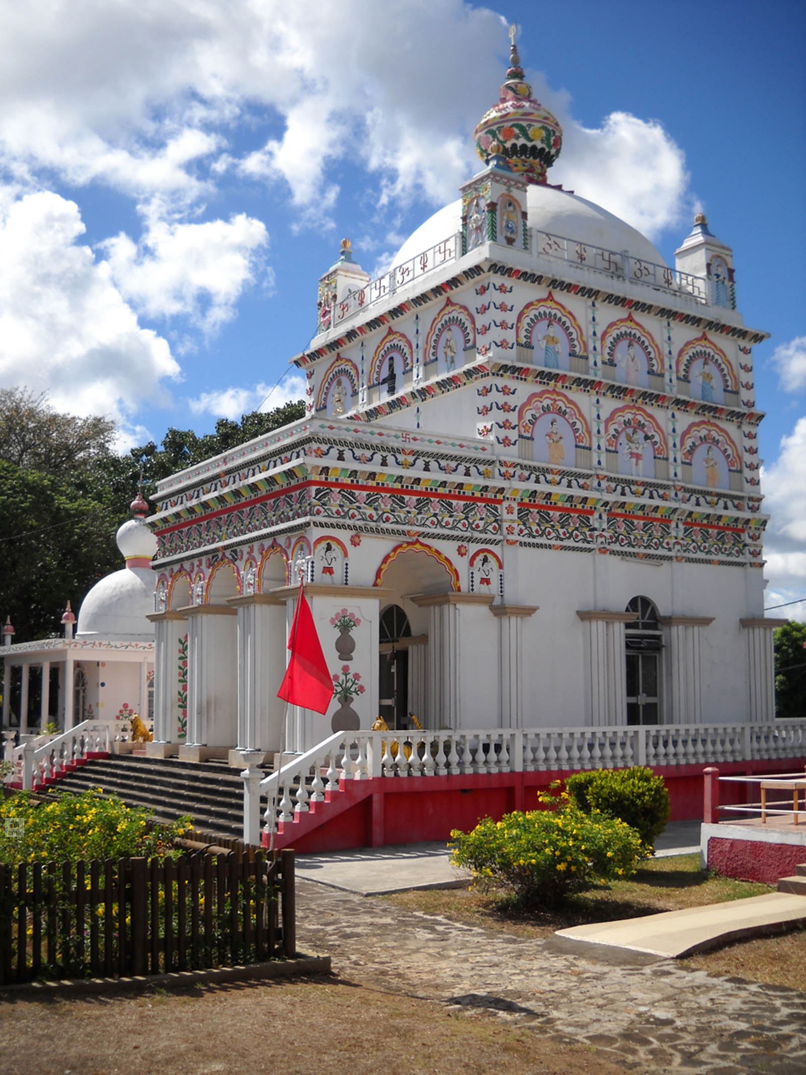 the colorful architectural structure features a bright red umbrella