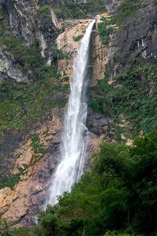 a mountain is shown with trees, and there is a waterfall