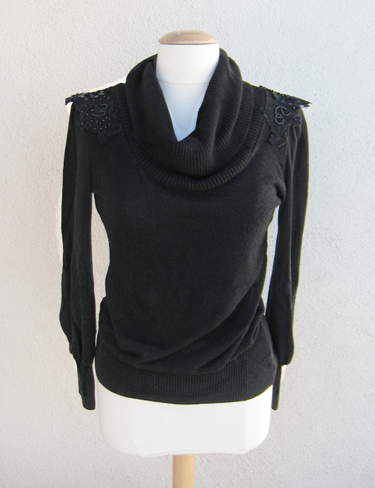 a dress form display with a sweater and black cowl