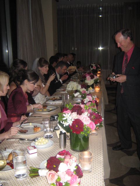 a table full of flowers, candles and a few people