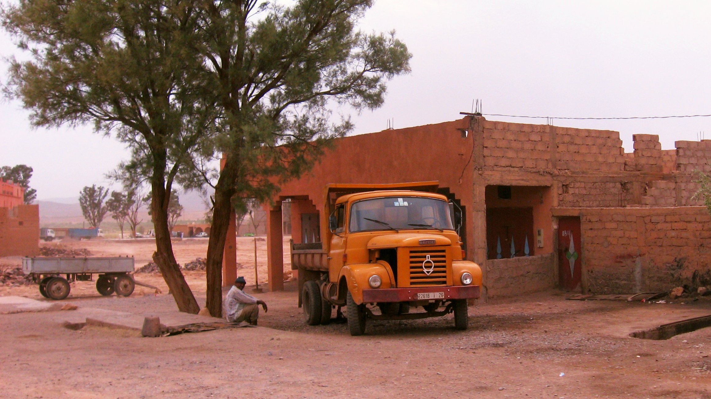 a yellow truck parked outside of a red brick building