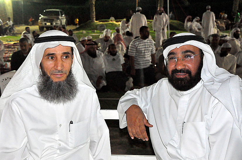 two men wearing white are posing for a picture