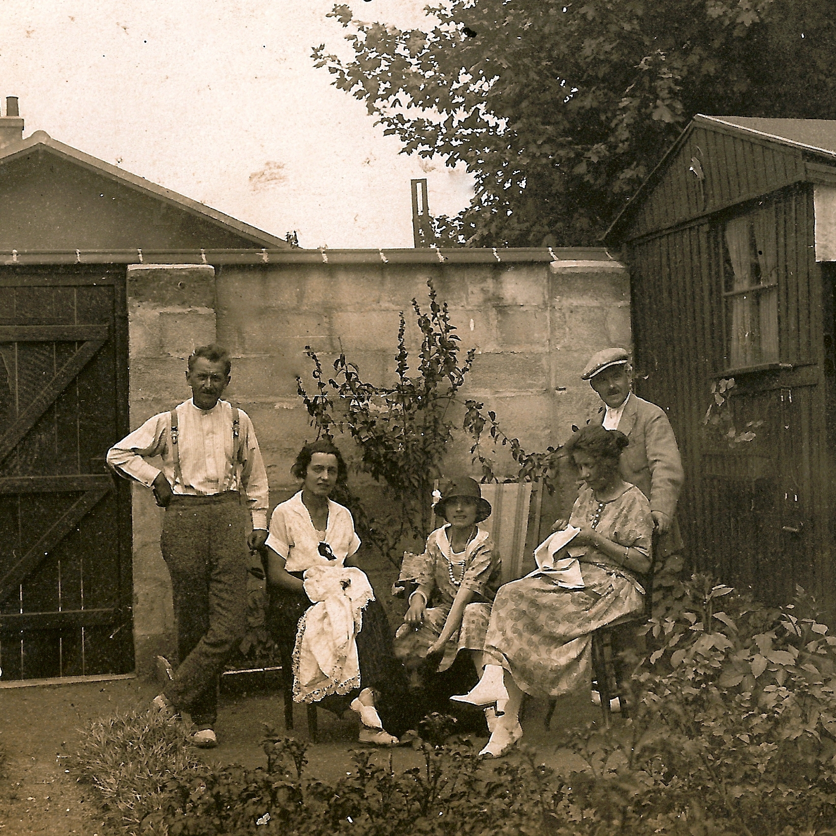 old time po of four people sitting around a fence