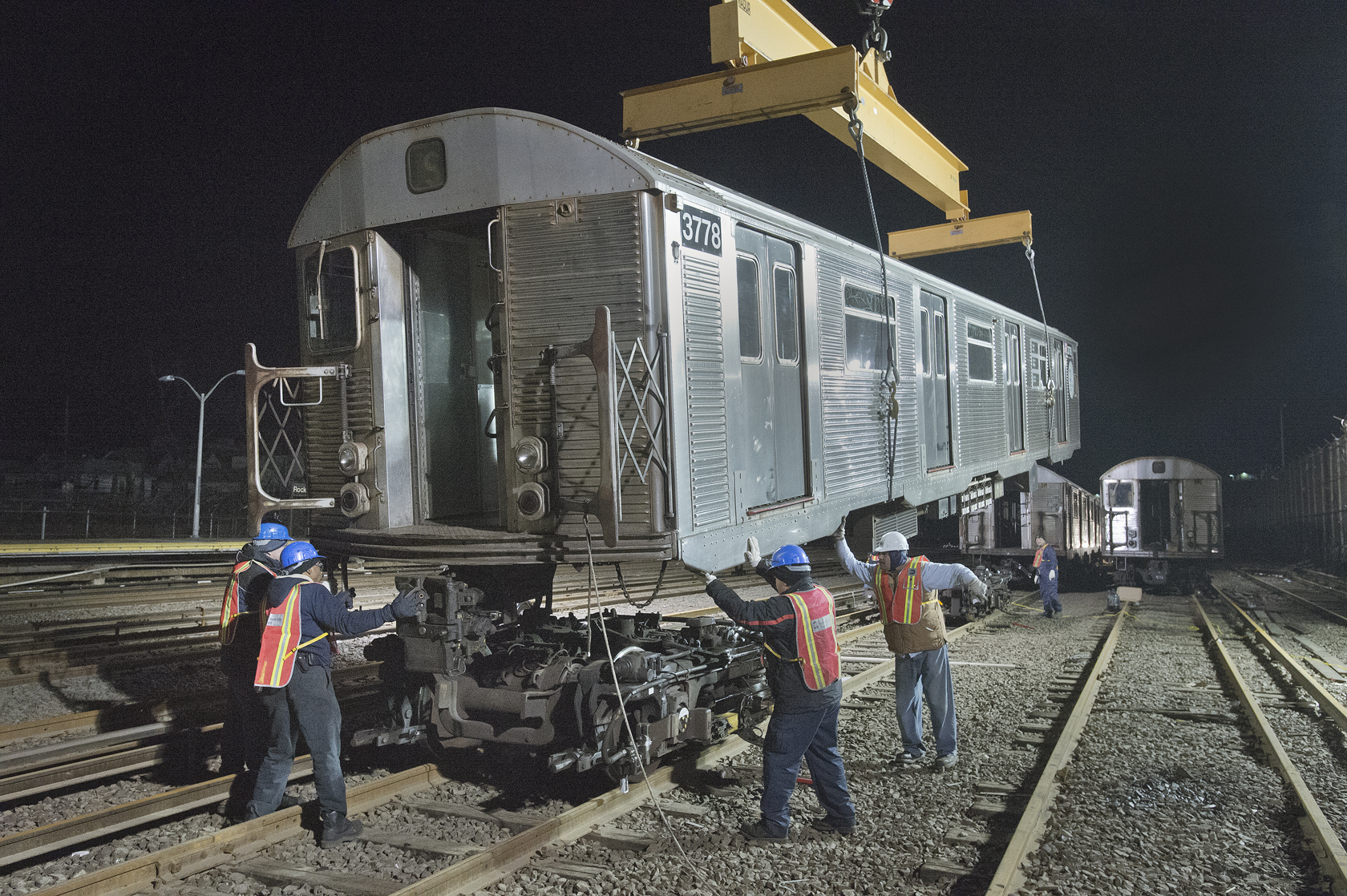 workers are working on the side of a train