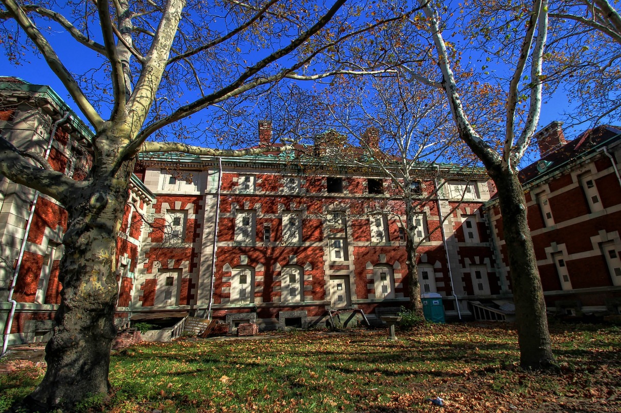 a tall brick building with several windows near trees