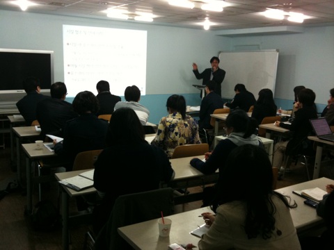 a teacher standing in front of a class while teaching