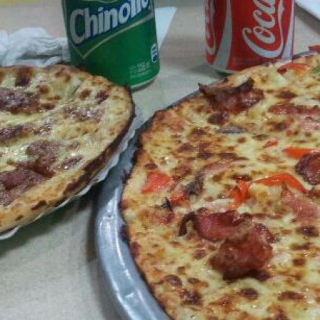there are two pizzas on the table and a coke