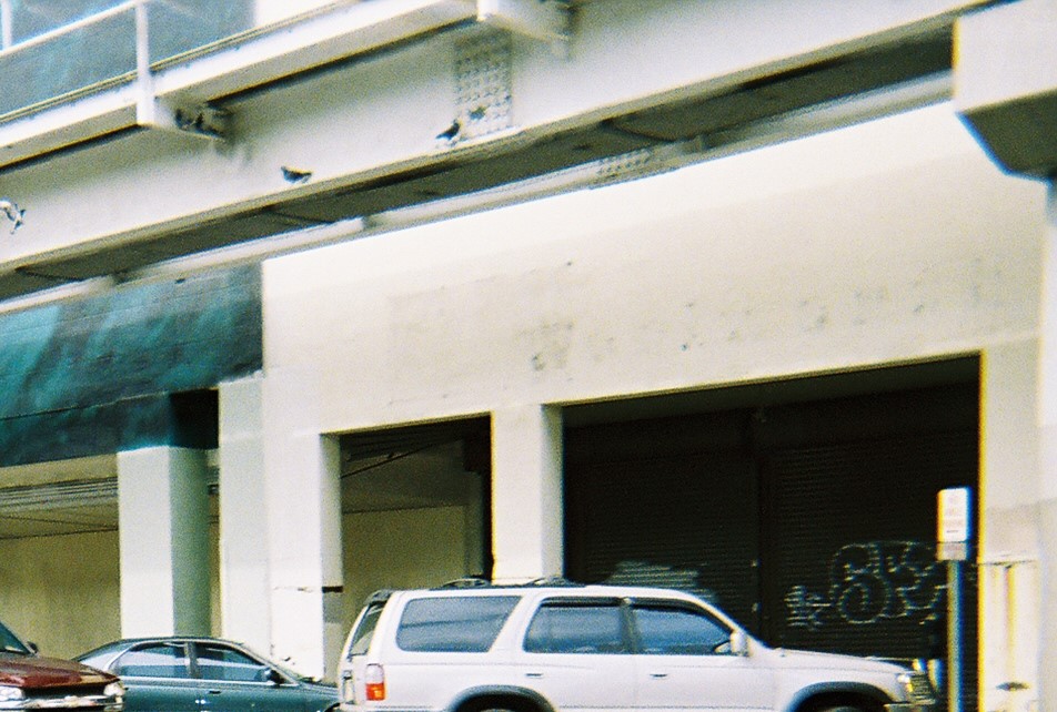 two cars are parked on the street in front of a building