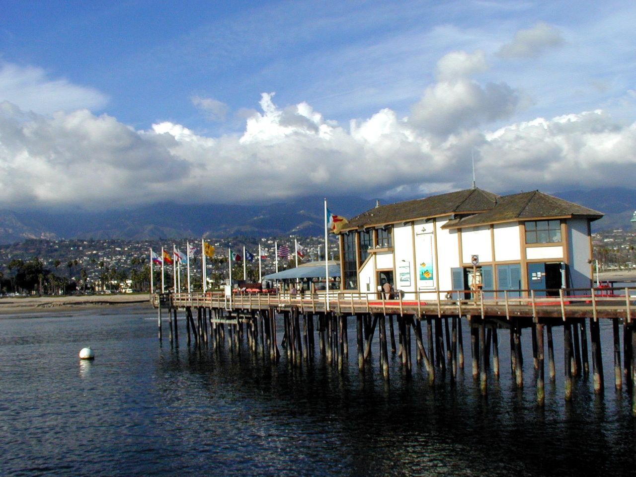 a pier next to a pier covered in clouds and water