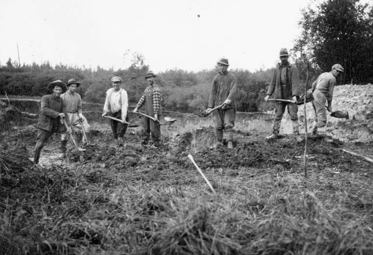 a group of men standing around holding their shovels