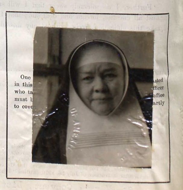 a nun sitting down holding a book