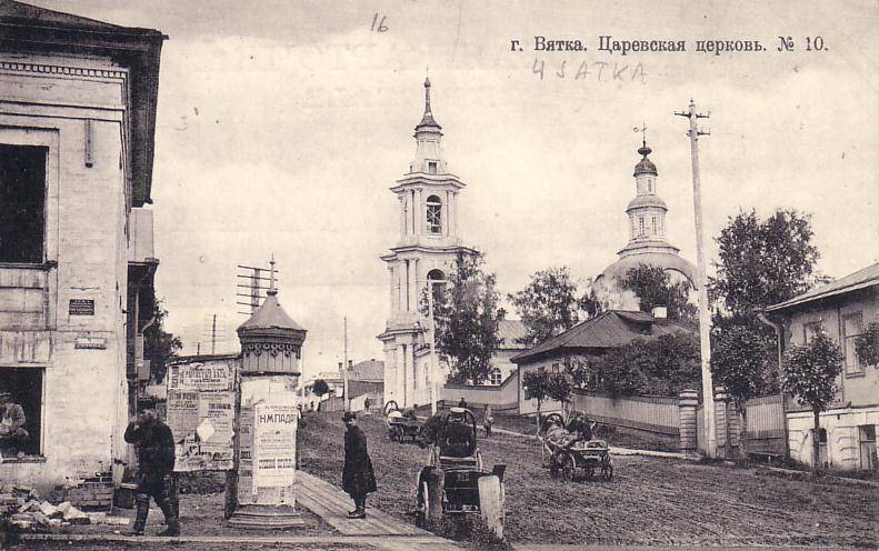 old time view of a town with buildings and cars
