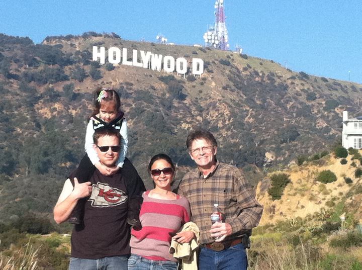 a family poses for a picture in front of the hollywood sign