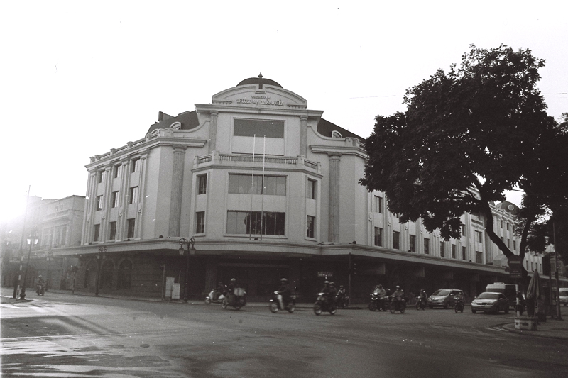 an old black and white po of people standing in front of a large building