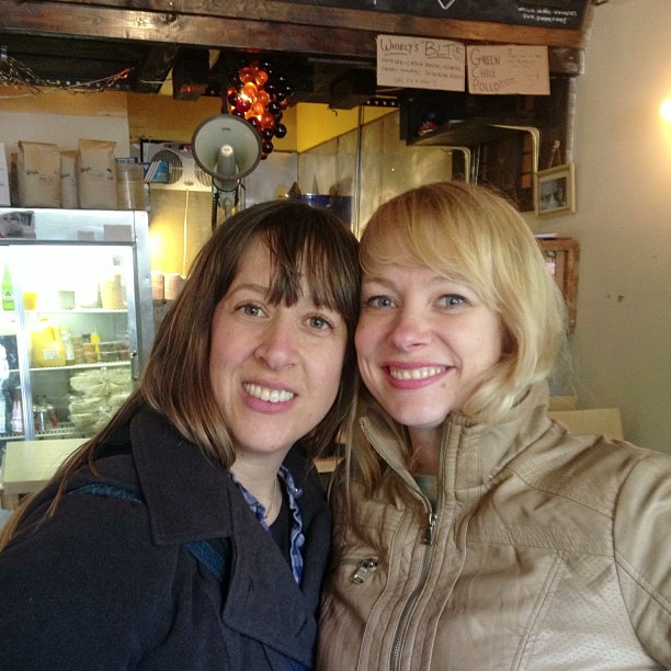 two women at the food counter posing for a po